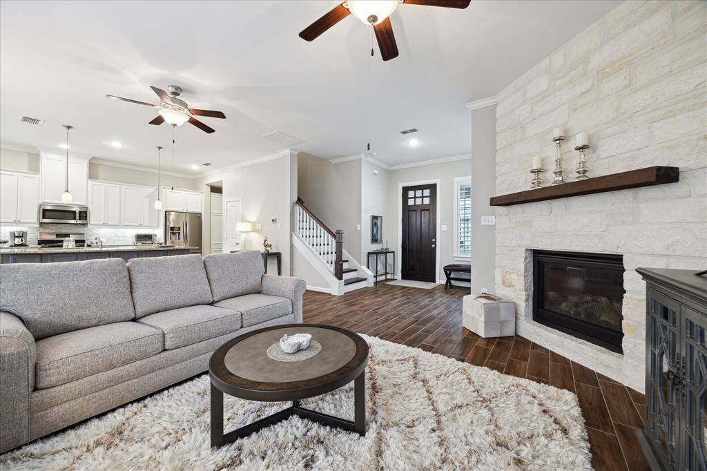 This inviting living area features an open-concept design with a cozy stone fireplace, a unique feature and upgraded by current owner.