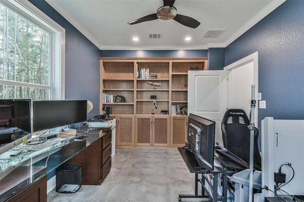 Home office adjacent to the primary suite, complete with built-in bookshelves, designer paint, and picturesque views