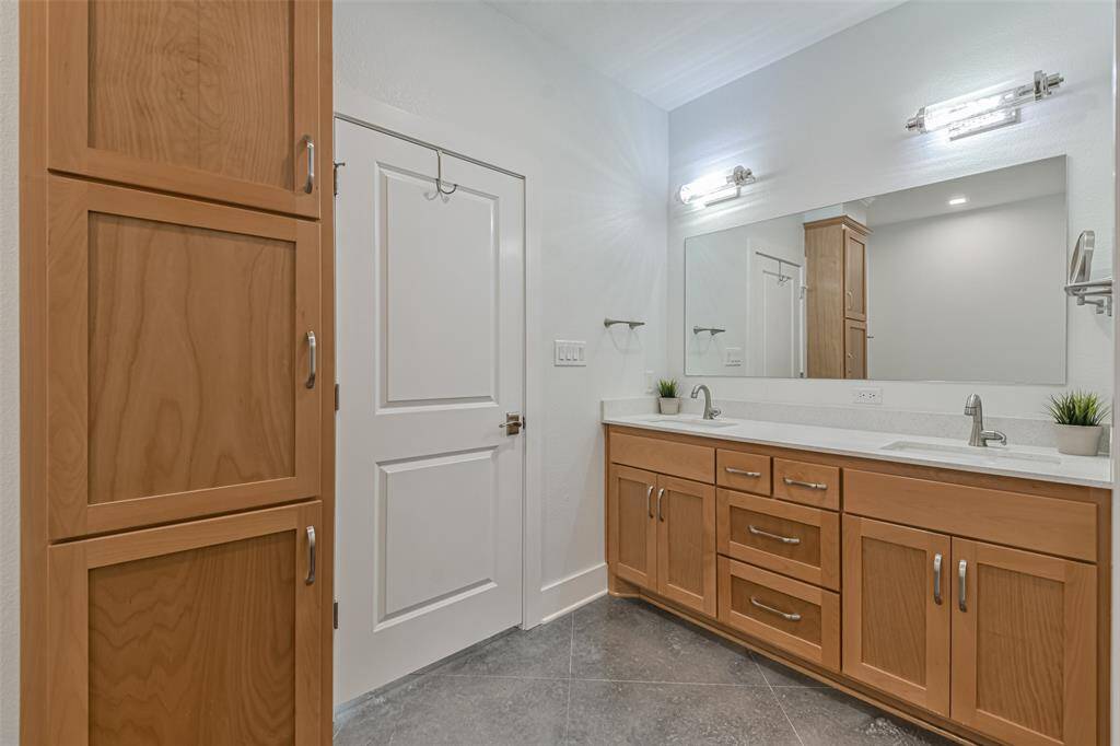 Luxurious primary bath boasting dual sinks and custom cabinetry