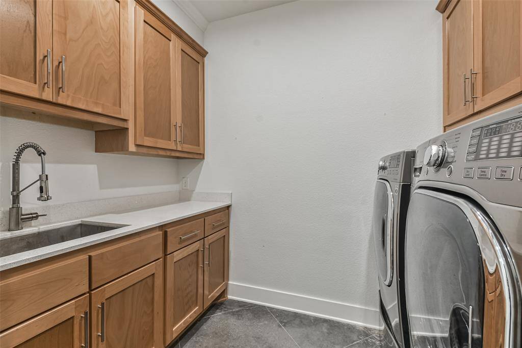 Laundry space includes a deep SS sink with industrial hardware, ample storage, and folding space.