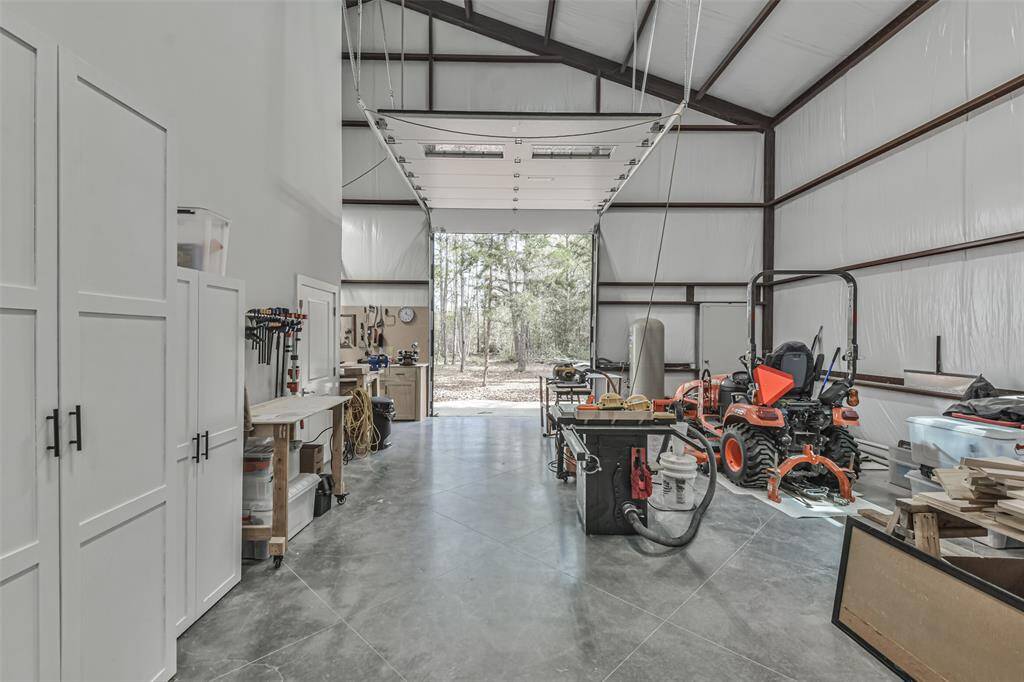 Spacious garage with large automatic roll-up doors, perfect for cars and RVs