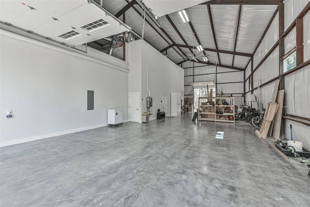 The expansive 70’x27’ garage features 26’ ceilings, accommodating 6+ cars