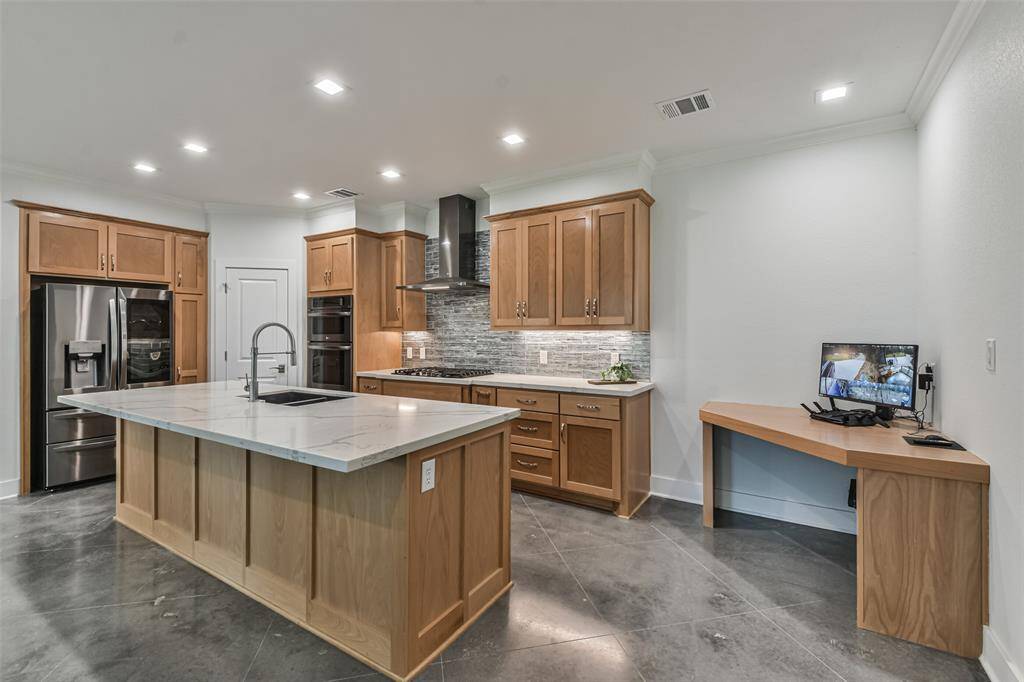 Chef’s delight kitchen equipped with a gas professional five-burner cooktop, stainless vent hood, under-cabinet lighting, convection microwave and oven, industrial kitchen faucet, designer cabinet hardware, and deep sink