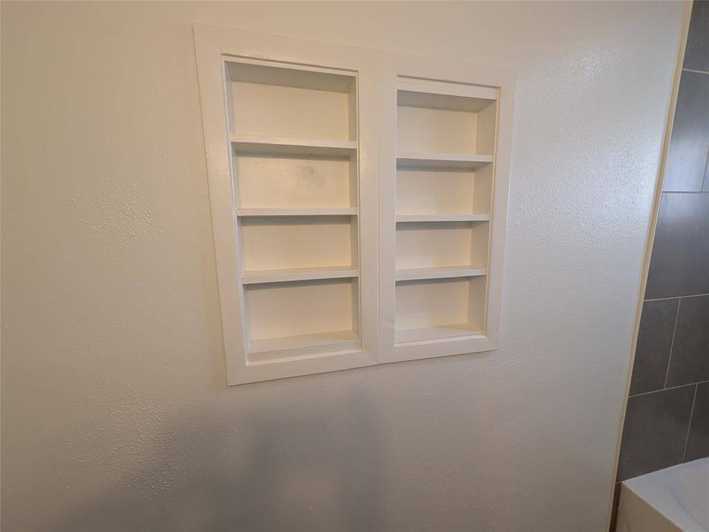 Built-in shelving recessed into a bathroom wall, providing convenient storage space.