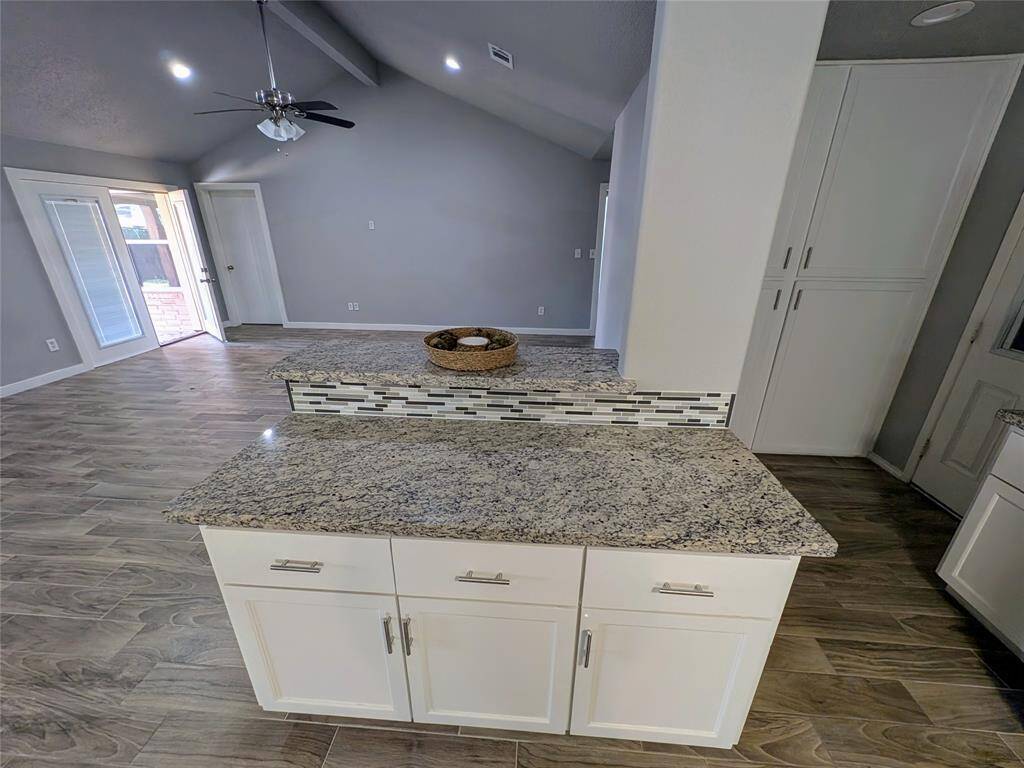 Open-concept kitchen features high counter space/bar