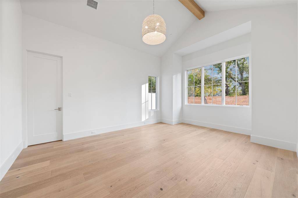 This luxury secondary bedroom suite is a serene retreat, offering both elegance and comfort. The room features a striking pitched ceiling, designer lighting, custom closet space, and en suite bath.