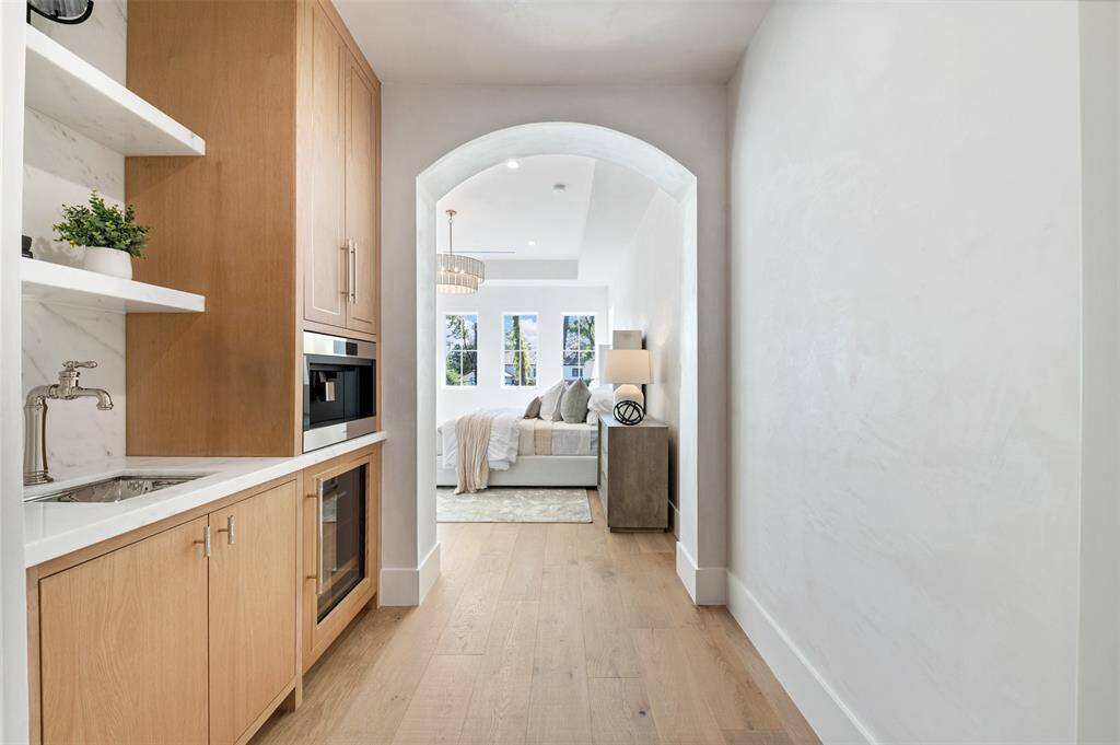This luxury beverage and coffee bar offers both style and convenience in one sophisticated space. A sleek built-in sink provides functionality for preparing drinks and cleaning up, while custom cabinetry offers ample storage for glassware, coffee essentials, and spirits.