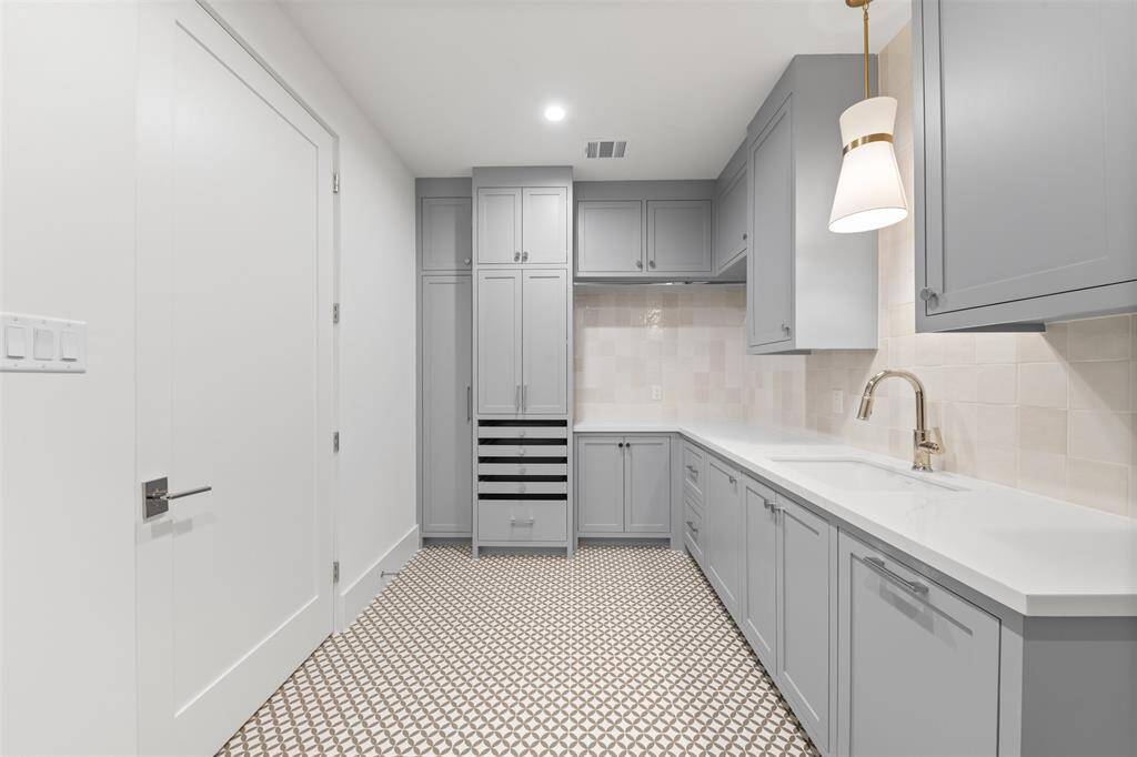 Off the primary suit a conveniently located utility room making laundry a breeze. As the second laundry room in the house, it perfectly balances convenience and elegance, seamlessly blending into the home’s luxurious aesthetic while serving as a dedicated space for everyday chores.