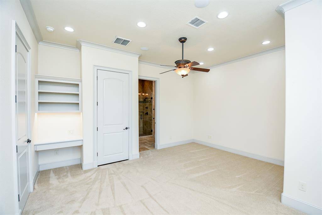 Secondary bedroom on 3rd floor with built-in desk and full private bathroom.