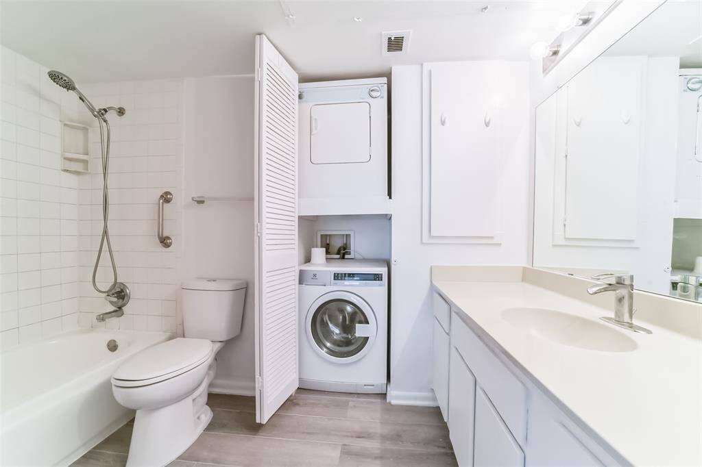 Smartly designed bathroom with a convenient in-unit washer and dryer.