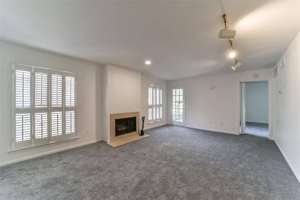 Brand-new carpet and fresh paint enhance this bright, sunlit room, which offers access to both the patio and bedroom.