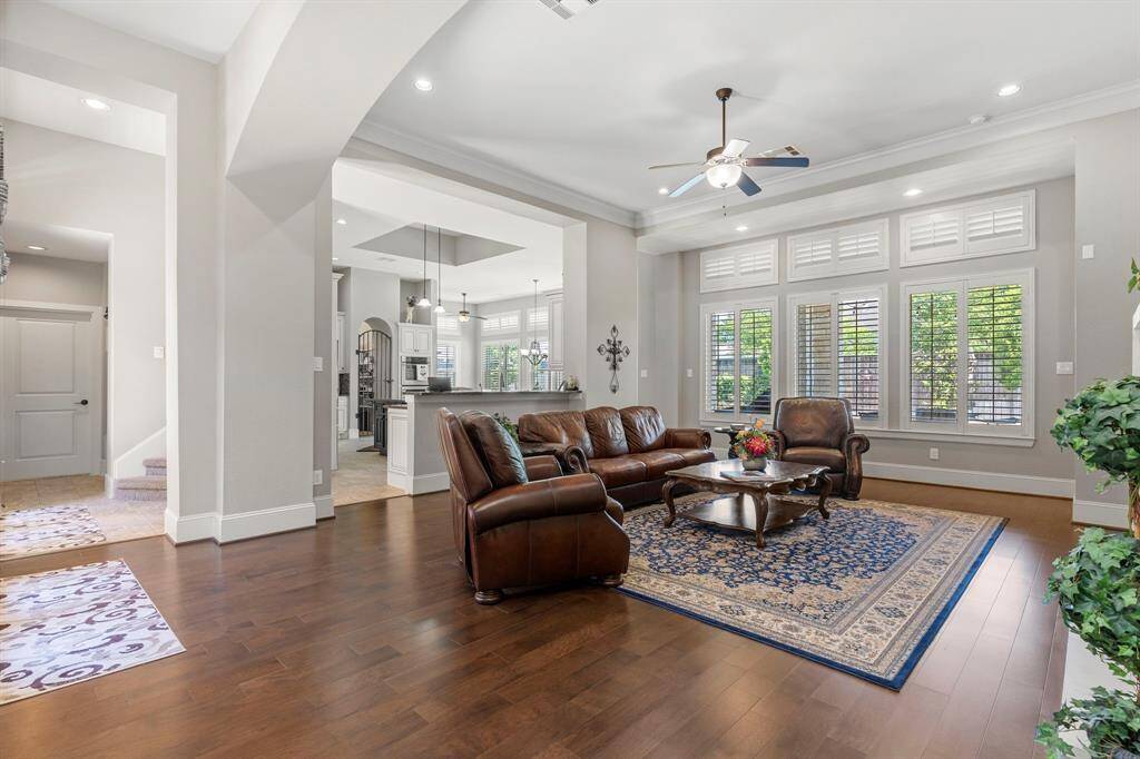 Wow! The dramatic high ceilings and stunning wood floors create an immediate wow factor! A wall of windows offers a view of your private, expansive backyard with a pool and spa. Gorgeous plantation shutters throughout add an elegant touch, making this home a true masterpiece. The spacious family area seamlessly flows into the impressive gourmet kitchen, perfect for any home chef. With high ceilings, a large breakfast bar, and more, this kitchen is sure to impress!