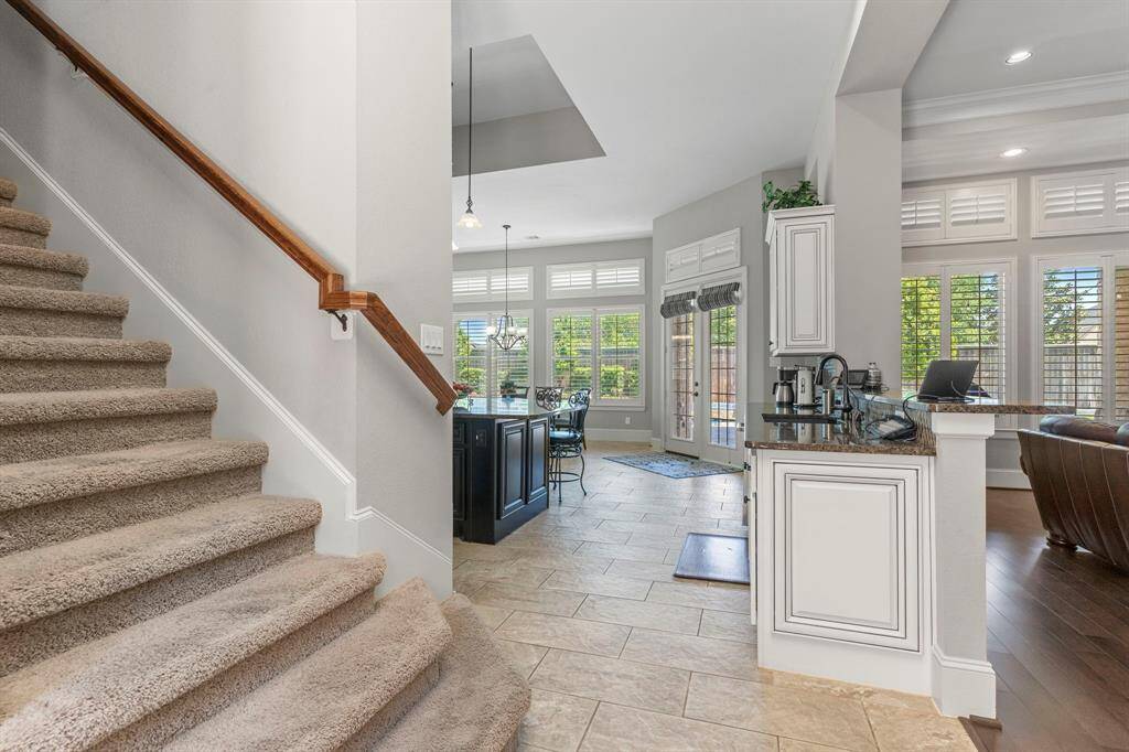Yes, this custom home features two stairways for added convenience and style! Plus, it offers both a downstairs and an upstairs laundry room—making everyday tasks a breeze. And when it comes to the kitchen, prepare to be wowed! The stunning large tile floors, laid in an upgraded brick pattern, welcome you into a truly gourmet kitchen designed for both beauty and function.