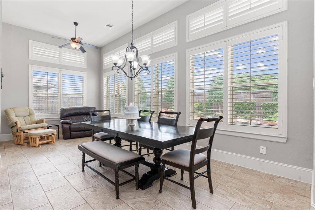 The bright and cheerful casual dining area seamlessly flows into the sunroom, both offering breathtaking views of your private backyard paradise. With no neighbors behind you, this space is a true retreat to relax and enjoy!