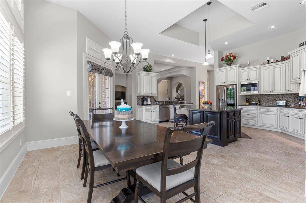 Huge casual dining area that looks into the gourmet kitchen and family area.  Look the stunning ceilings and how this gourmet kitchen surrounds you with amazing, beautiful cabinets and countertops for all your cooking needs!