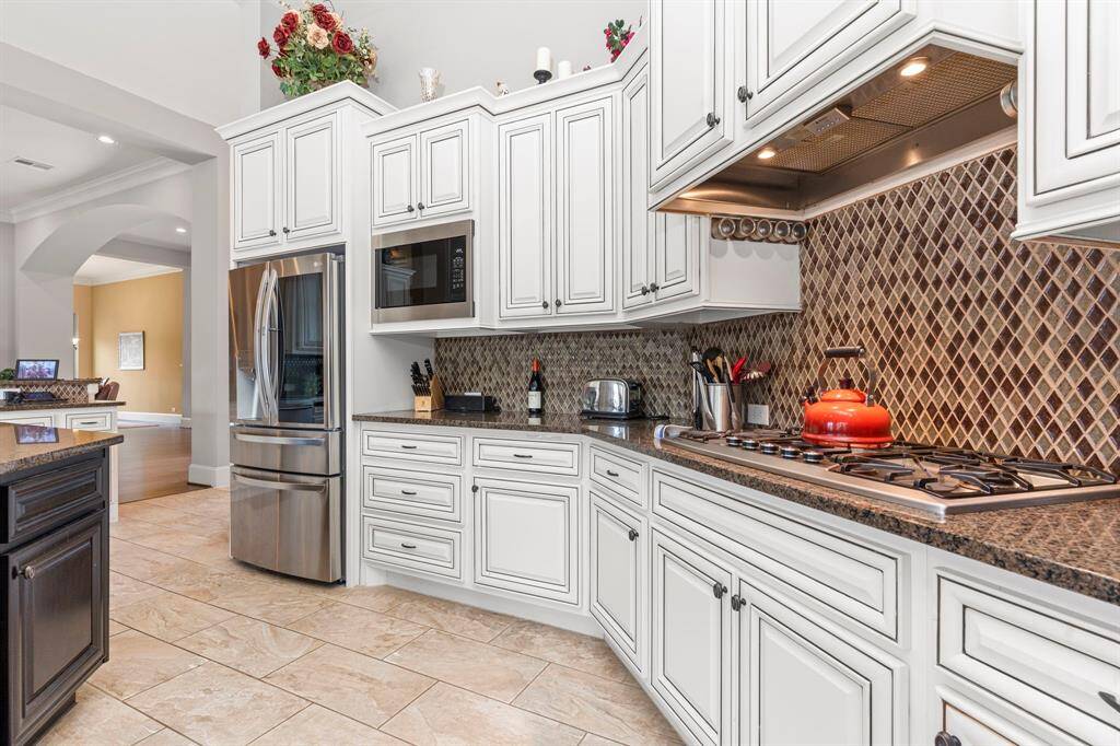 This gourmet kitchen will surround you with exquisite tall custom cabinets, a striking custom tile backsplash, gorgeous granite countertops, a deep undermount sink, and so much more creating a space that's as beautiful as it is functional!