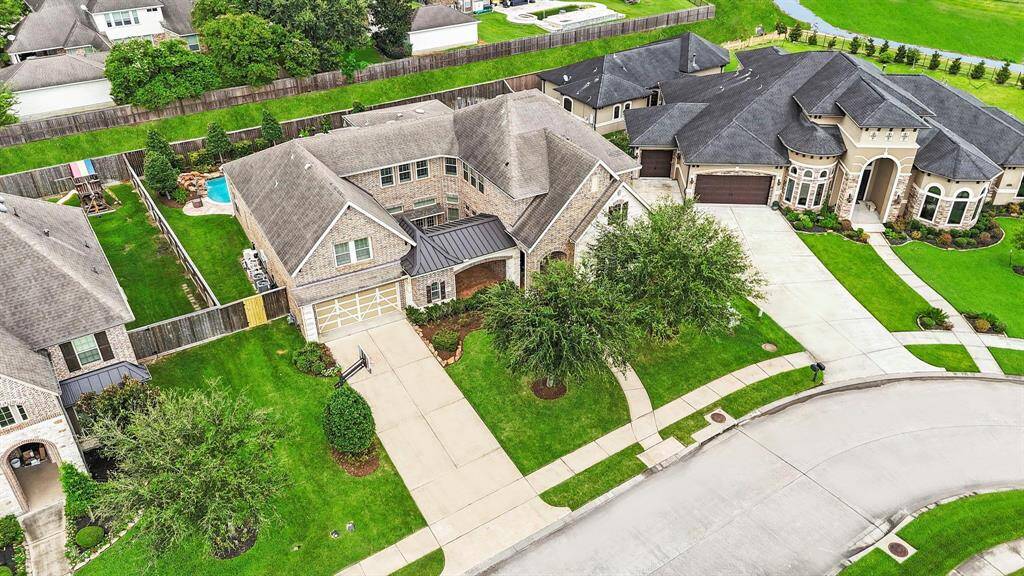 An aerial view of the front of the home highlights the private courtyard, a long driveway offering ample parking, and so much more!  Gate in the back of the yard to take a nice walk!  No one will ever be behind you  this is an easement!   No flooding during any of the storms! Low taxes and amazing schools for all ages!