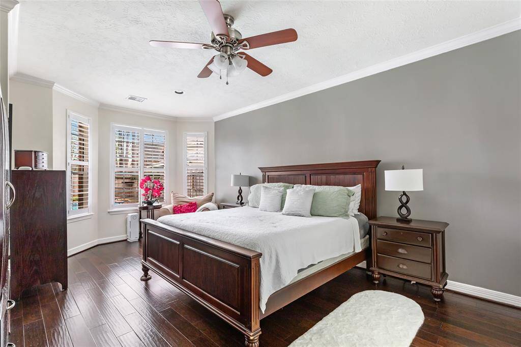 Owner's retreat is lovely and located downstairs. Accent wall and engineered hardwood flooring in this main area.