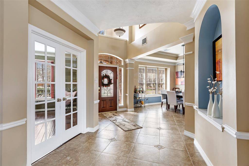 Hallway view to the front door. Formal dining room to the left as you enter. Home office with double French doors to your right.