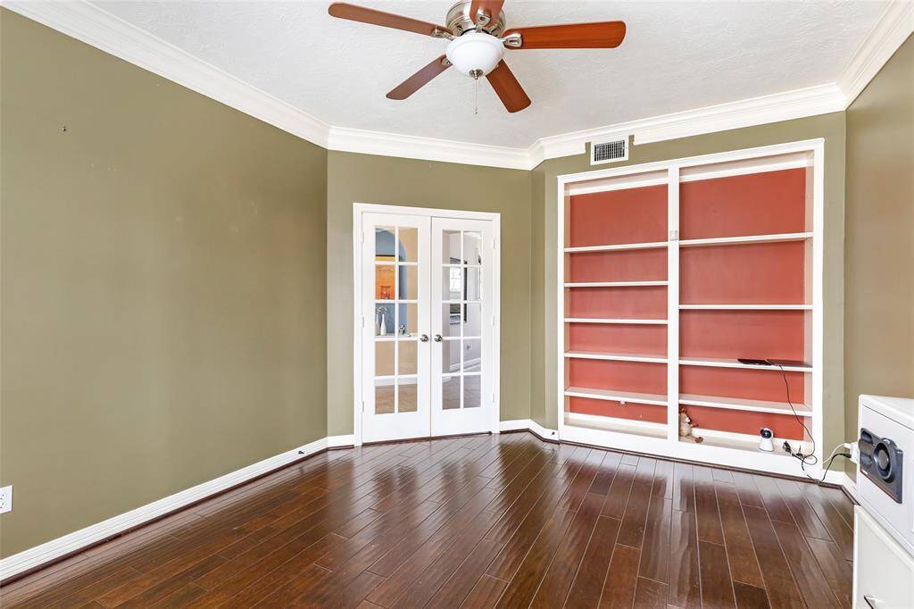Home office has engineered hardwood floors as well as built in shelving.