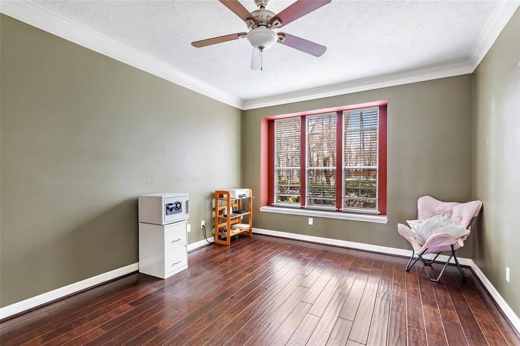 Home office has engineered hardwood floors and triple windows for front yard views.