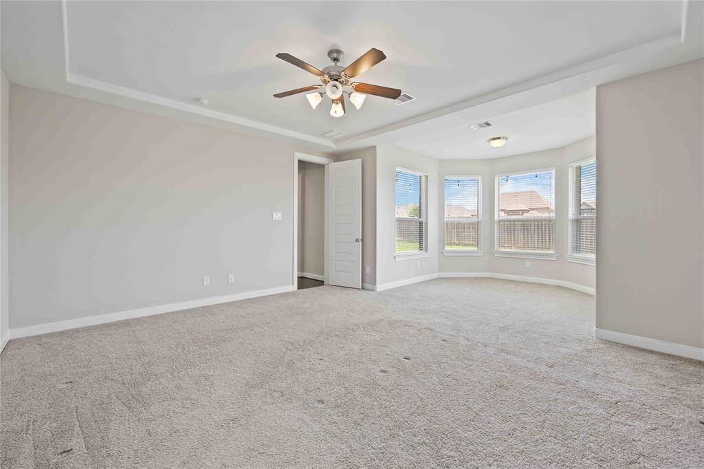 large primary bedroom with bay windows
