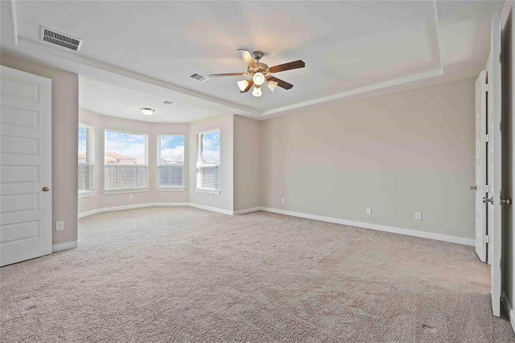 large primary bedroom with bay windows