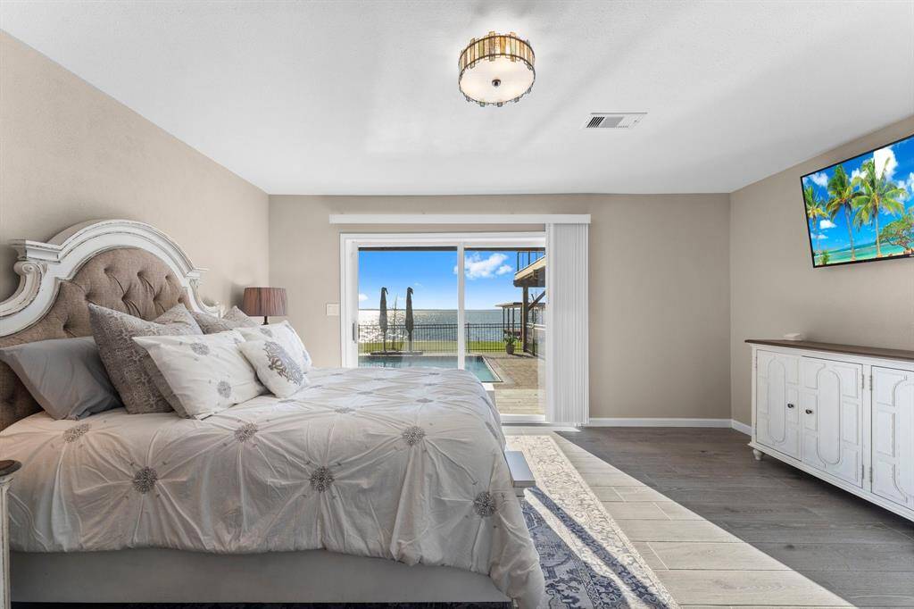 The primary suite has an  impeccable view of the backyard, pool and lake