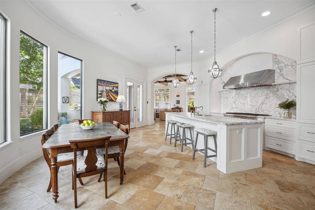 The kitchen, the centerpiece of the home, connects to the dining room and great room via graceful archways. Highlights include top of the line Thermador appliances, a generous island with integrated sink, carrara marble countertops and backsplash, and expansive cabinet space and storage.