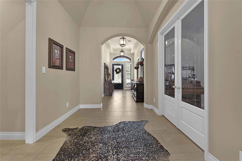 As you proceed through the entry, you'll be greeted by elegant curved archways and soaring vaulted ceilings. The tile flooring continues seamlessly, enhancing the open and airy ambiance throughout the home. Each architectural detail adds to the overall charm and sophistication, making it a delightful space to enjoy.