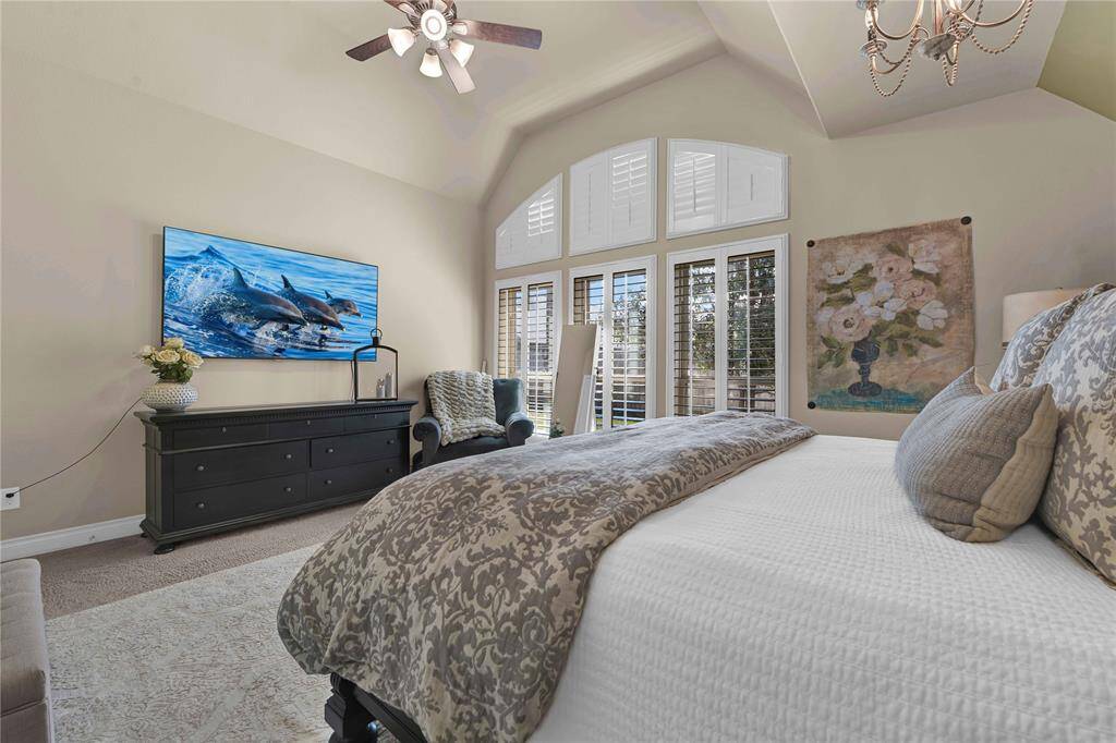 A stunning wall of large windows, complemented by elegant transom windows & fitted with plantation shutters, floods the space with natural light, enhancing the room's warmth & tranquility. This serene environment is ideal for unwinding after a long day, offering a peaceful retreat where you can escape and recharge.