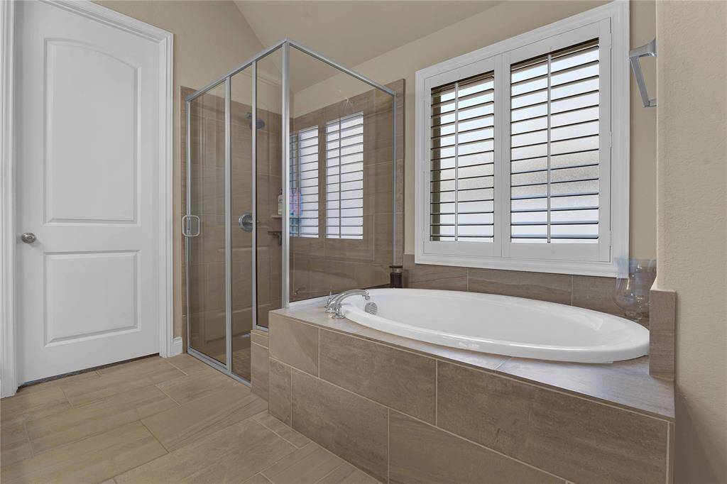 For a quick rejuvenating experience, the ensuite bathroom features a walk-in shower, designed for both convenience and a refreshing escape. For those moments when you need to unwind, a spacious garden tub offers the perfect sanctuary for a relaxing soak after a long day.