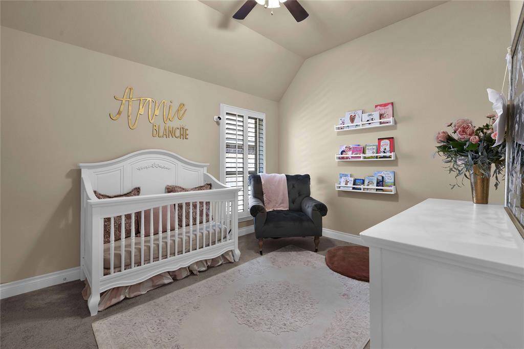 The third & final secondary bedroom features a high ceiling with a ceiling fan, creating an airy & comfortable atmosphere. A large window fitted with plantation shutters allows natural light to fill the room while providing privacy when needed. Plush carpet underfoot adds warmth & coziness, making it a perfect retreat.