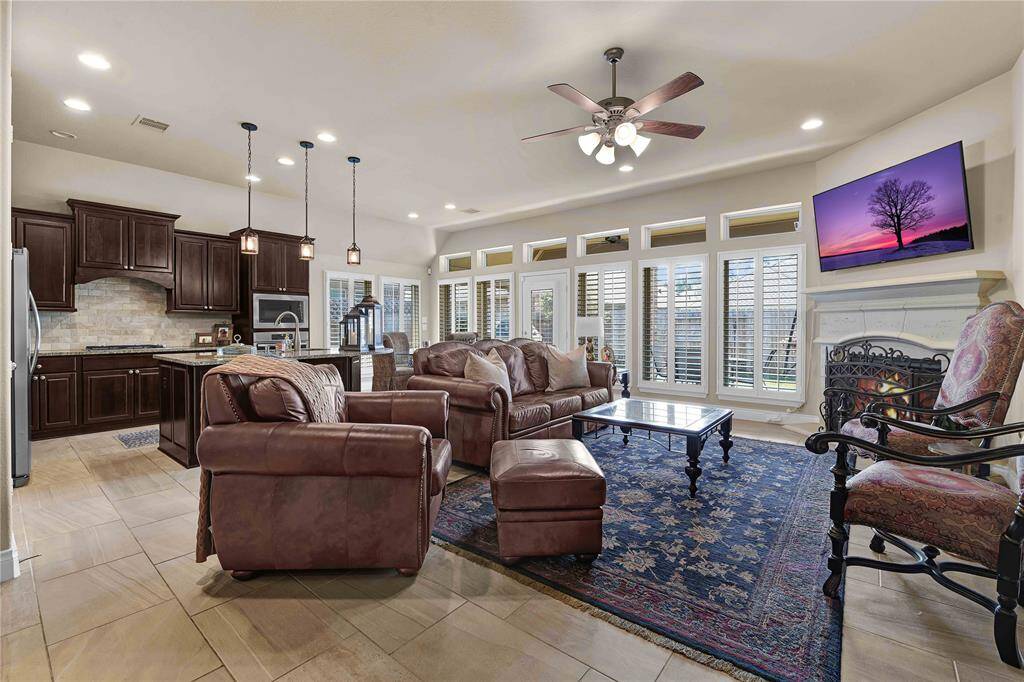 At the heart of this open floorplan lies the spacious family room, designed for both relaxation and entertainment. Large windows stretch across the entire back wall, complemented by stylish transom windows above, ensuring that natural light pours in throughout the day.