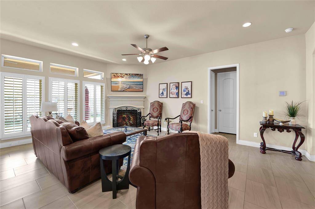 The elegant elongated tile flooring flows effortlessly throughout, providing a modern touch that is easy to maintain. Overhead, the high ceilings are accentuated by recessed lighting, creating a bright and airy ambiance that enhances the room’s openness.