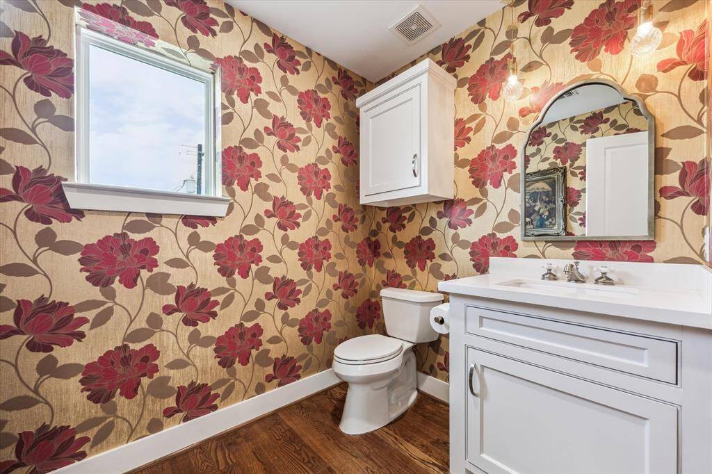 Step into this stunning powder bathroom, where elegance meets functionality. The large, airy layout is elevated by sophisticated wallpaper, adding texture and a touch of luxury to the space. Soft, ambient lighting enhances the intricate patterns, creating a warm and inviting atmosphere. A statement vanity with high-end finishes and sleek fixtures completes the look, making this powder room both practical and effortlessly stylish.