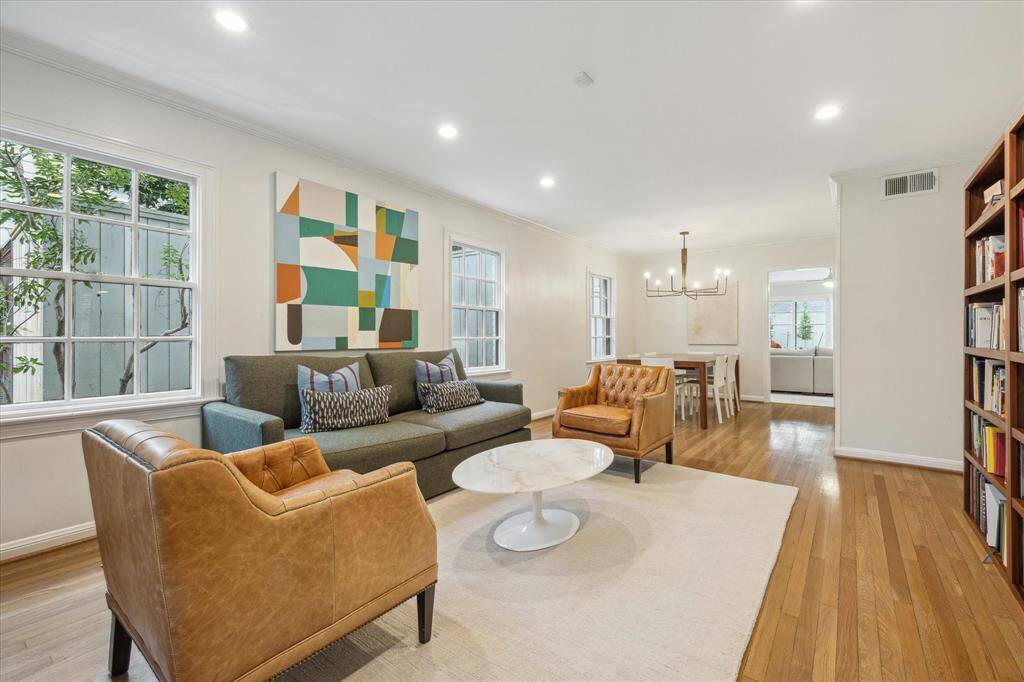 Formal living room is open to the Dining room with hardwood floors, windows overlooking the front and side yards, and recessed lighting.