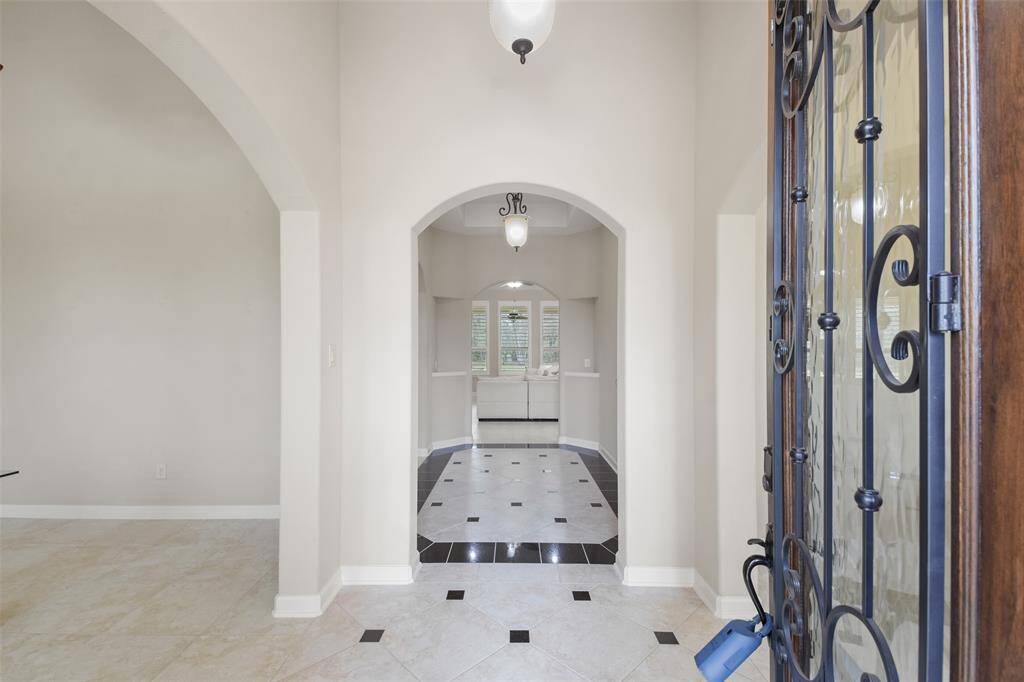 Entry way leading to a foyer with the office space to the left and the formal dining to the right