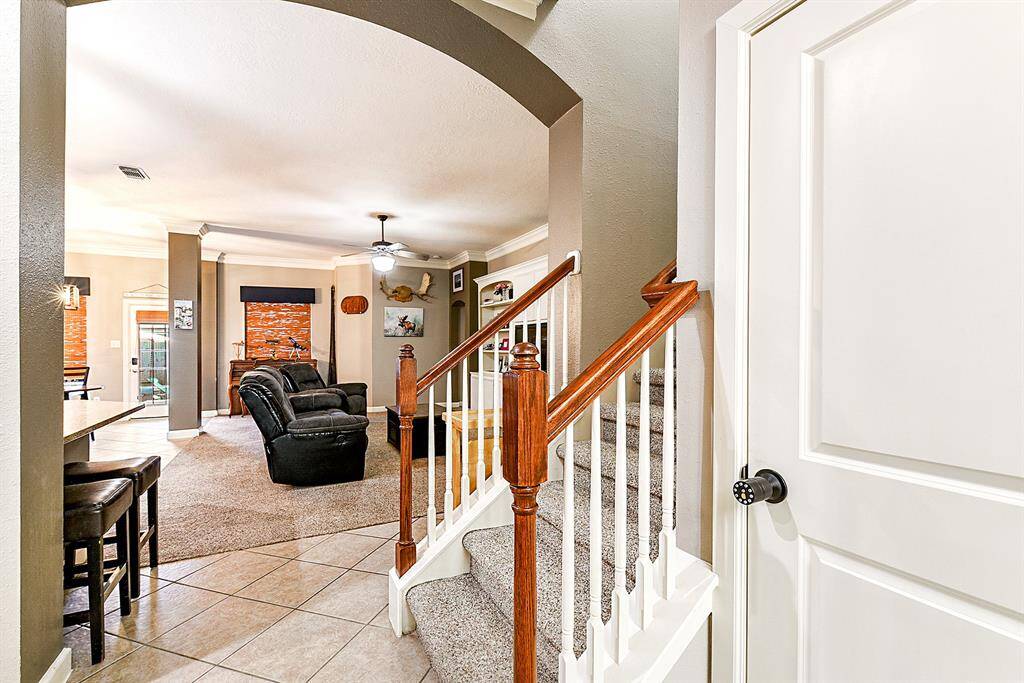 The wide foyer entrance provides incredible views stretching from the front door to the back door. To the right, you'll find a coat closet, while the staircase leads to the upstairs game room.