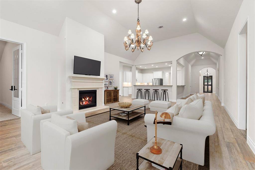 The heart of this home is so large and impressive. The family room with gorgeous chandelier has tall ceilings, a fireplace and is open to the island kitchen with bar seating for 8. Virtually staged.