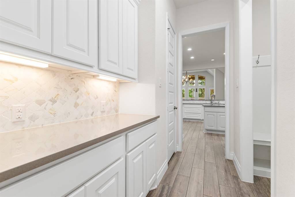 Butler's pantry with under cabinet lighting located between the dining room and the kitchen.