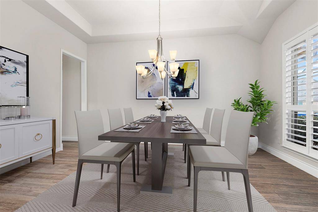 Formal dining room with tray ceiling and plantations shutters. Virtually staged.