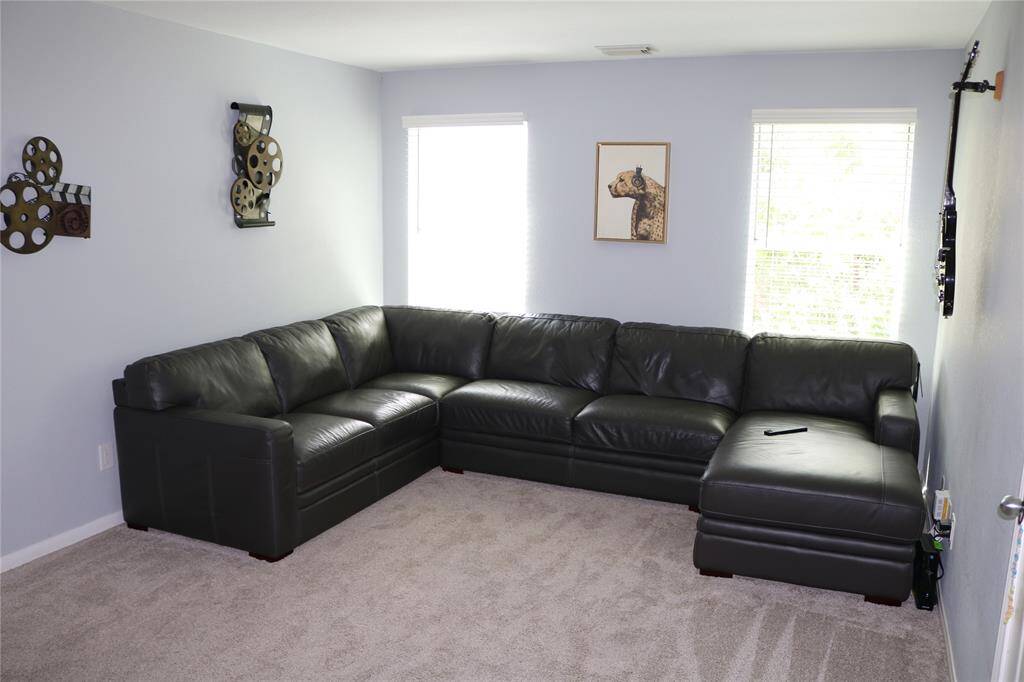 The play area is a bright and airy space, featuring two long windows that flood the room with natural light. This creates a lively and inviting environment for playtime. The area is also conveniently located with easy access to the adjacent bedrooms, making it both practical and enjoyable for children.