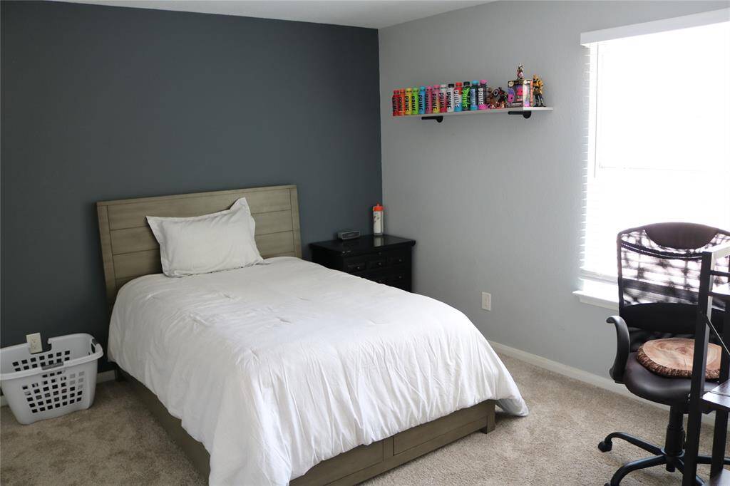 The multi-functional secondary bedroom features carpeted flooring. The space is well-lit with a window providing natural light.