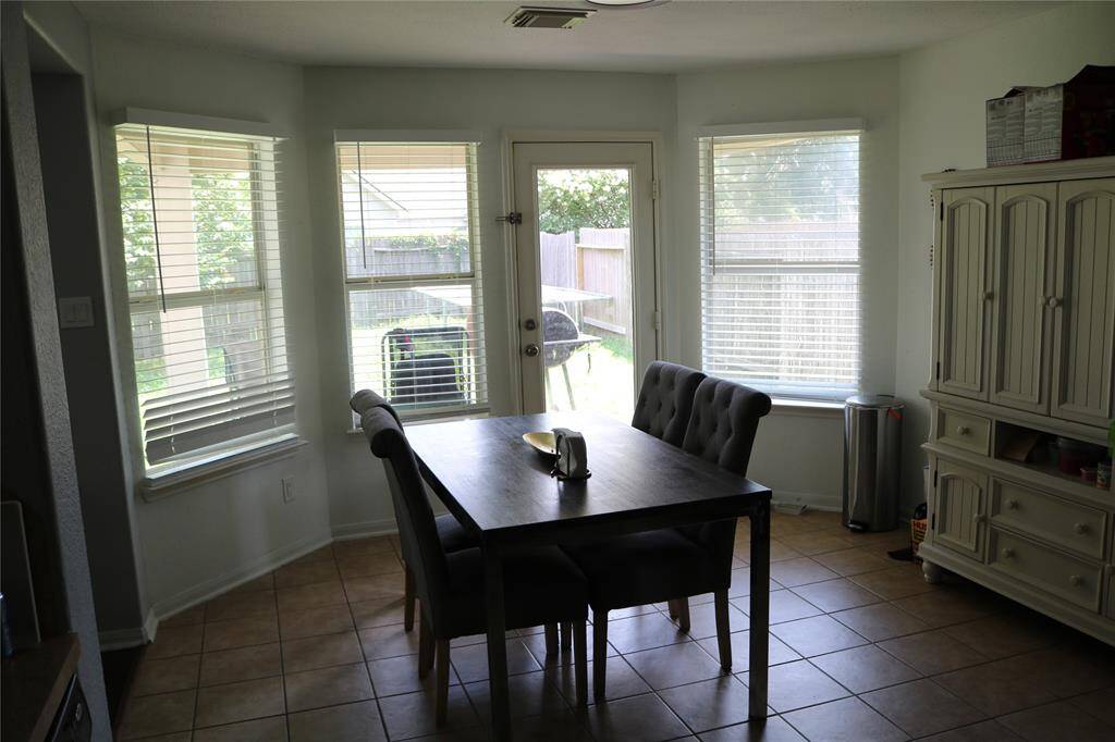 undefined The charming breakfast area is bathed in natural light, thanks to its large windows that brighten up the space and offer a picturesque view of the backyard. With easy access to the outdoor area, this space is perfect for enjoying morning coffee or casual meals in a sunny, serene setting.