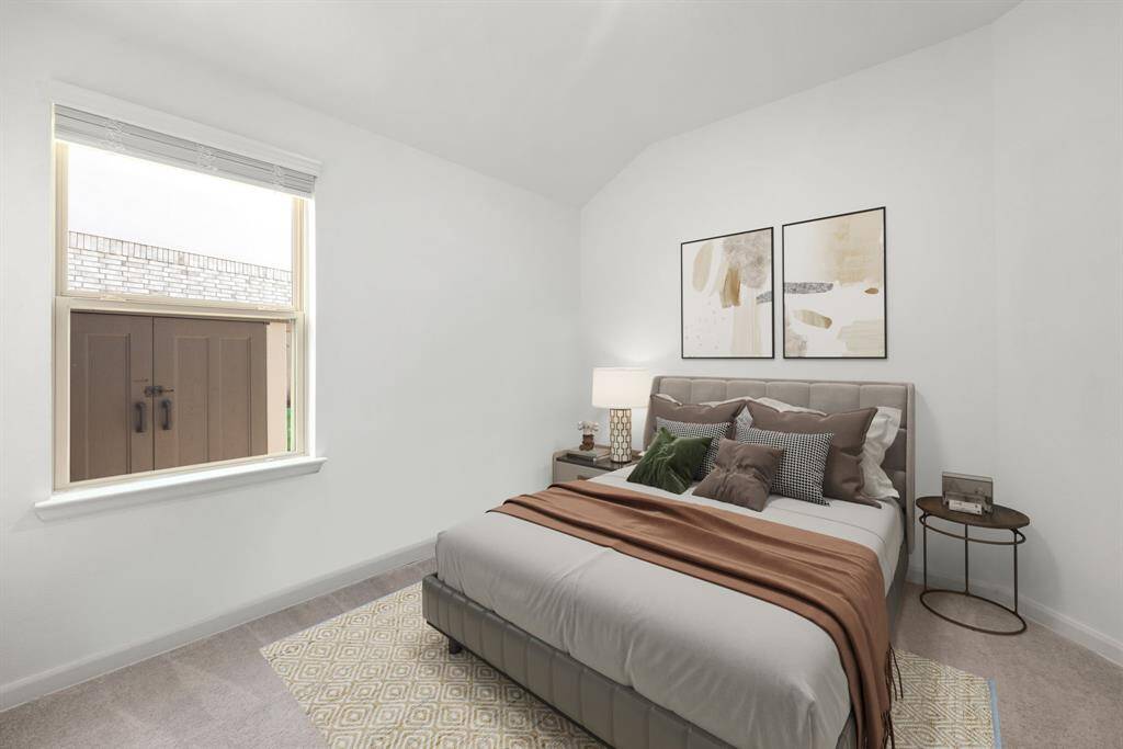 Secondary bedroom features plush carpet, neutral paint and a large window with privacy blinds.