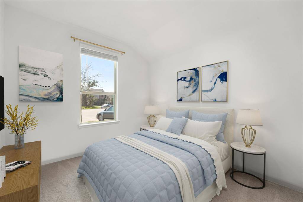 Secondary bedroom features plush carpet, neutral paint and a large window with privacy blinds.