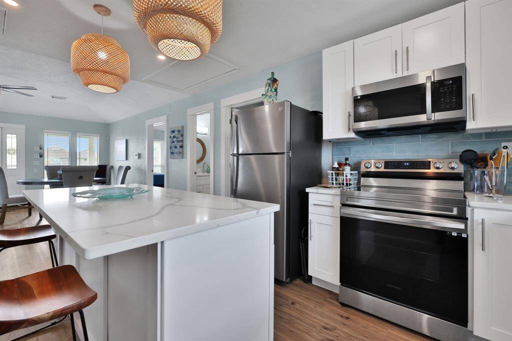Beautiful Quartz Countertops and glass tile backsplash.
