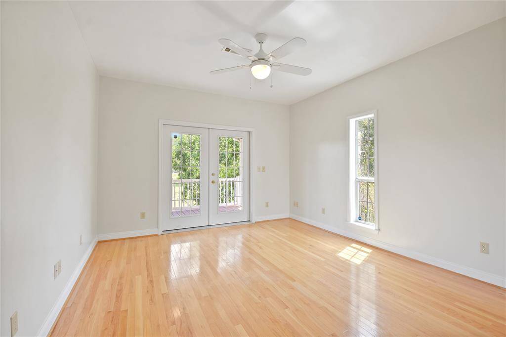 This is the third bedroom on the main level.  It is at the end of the hallway and next to the hallway full bath.  Flooded by natural light from two sides, this room has gleaming hardwood flooring and access via French doors to the covered veranda along the back side of the home.