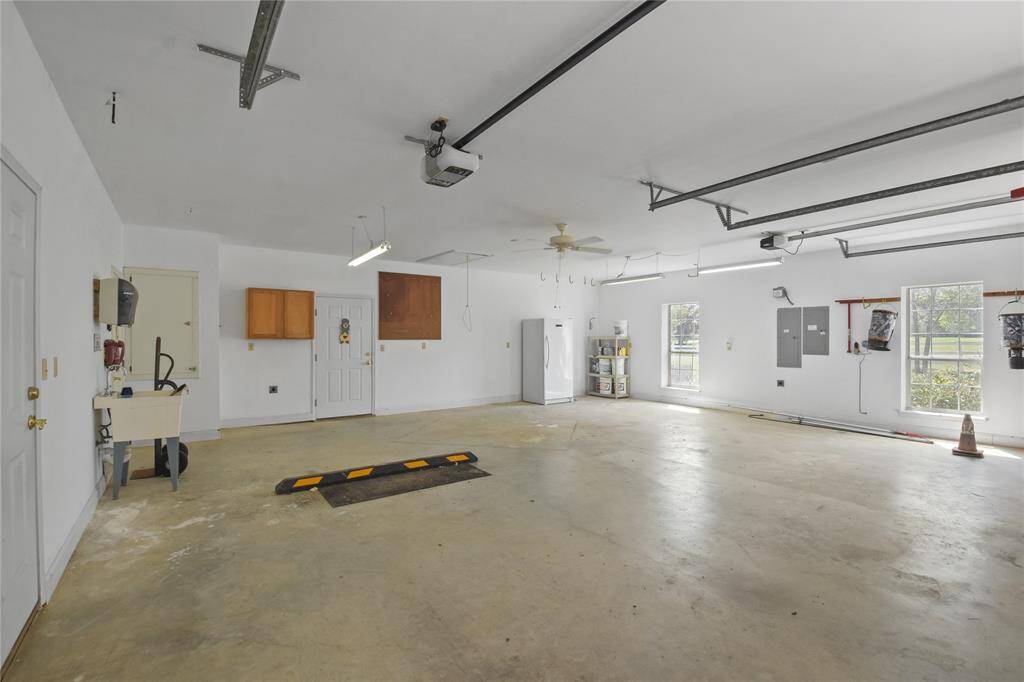 The oversized two car garage with plenty of space for vehicles, boats, etc. plus use as a workshop area also. There is plenty of lighting, a dedicated large work area sink. plus room for multiple extra refrigerators or freezers.  Lots of floor space for bicycles, motorcyles, and everyone's favorite recreational toys!